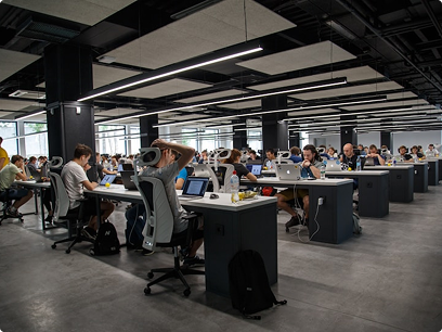 An open-plan office with rows of desks and people working at them.