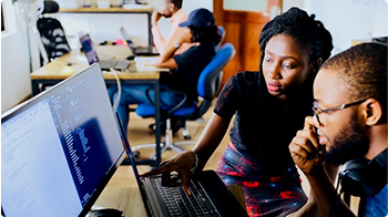 Two people working together on a computer.